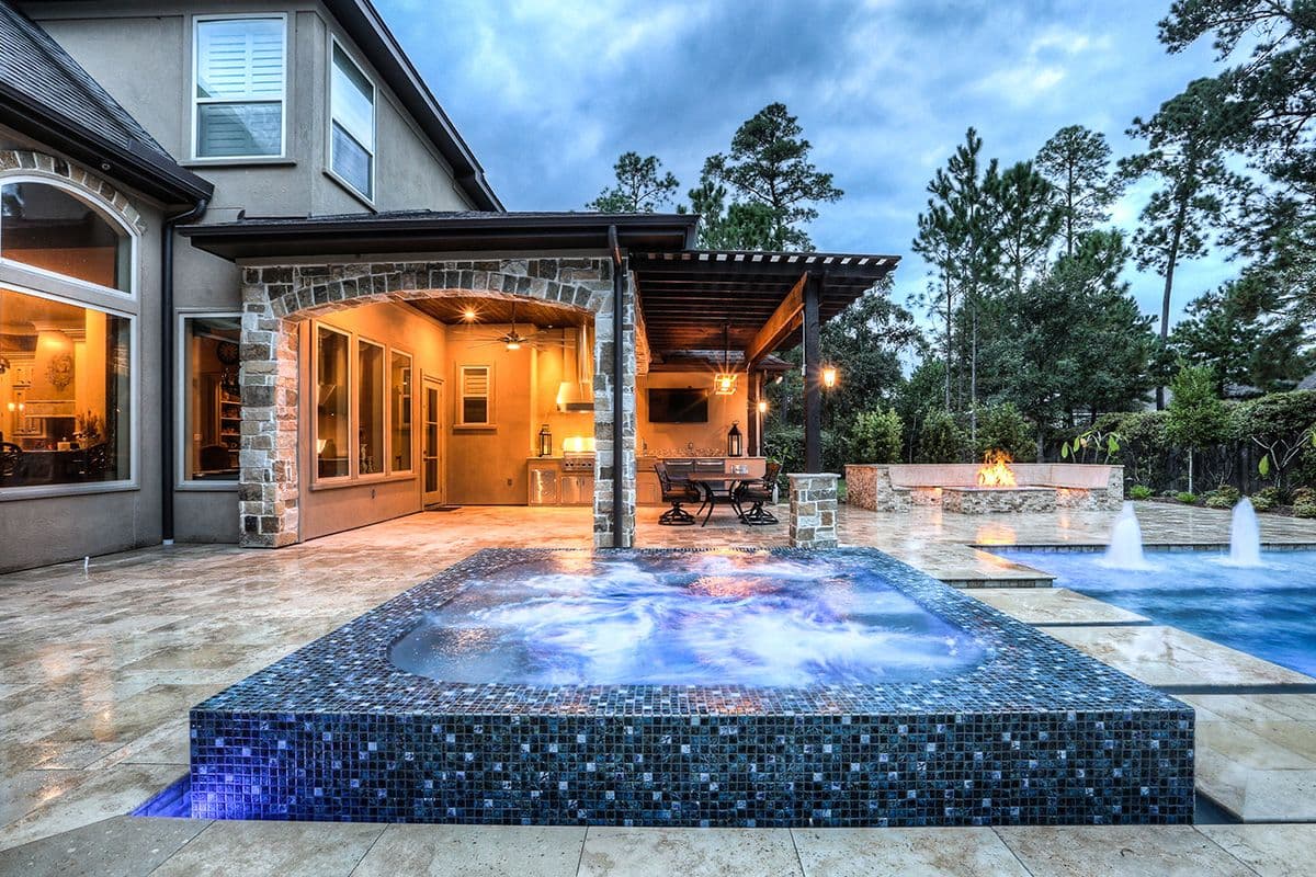 Brightly lit backyard pool at dusk.