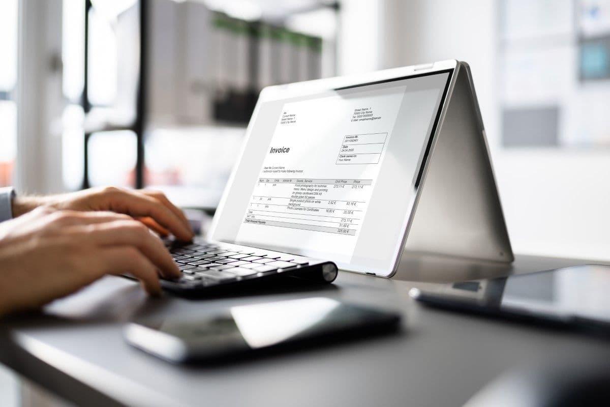 Person paying an invoice with a tablet and keyboard.